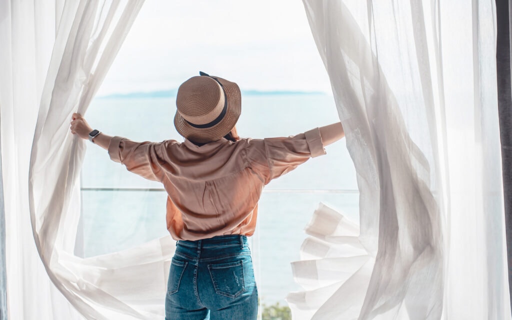 woman on her travel loan holiday in front of a window