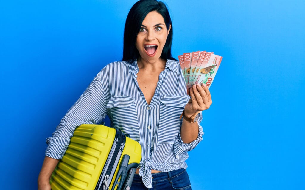 Woman who took out a holiday loan standing with suitcase