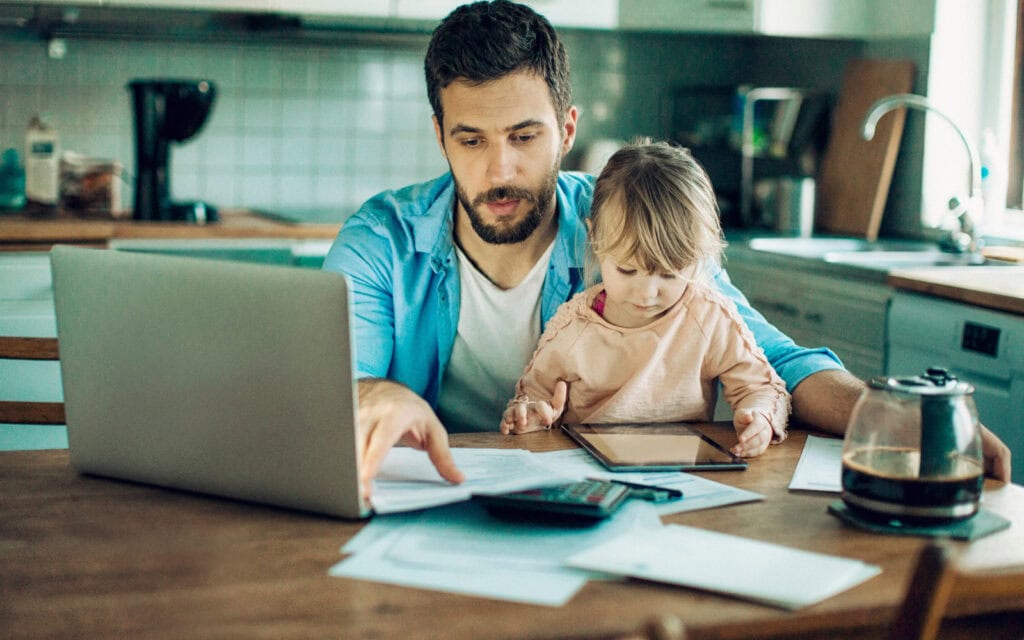 Father at a lap top applying for a $500 dollar loan