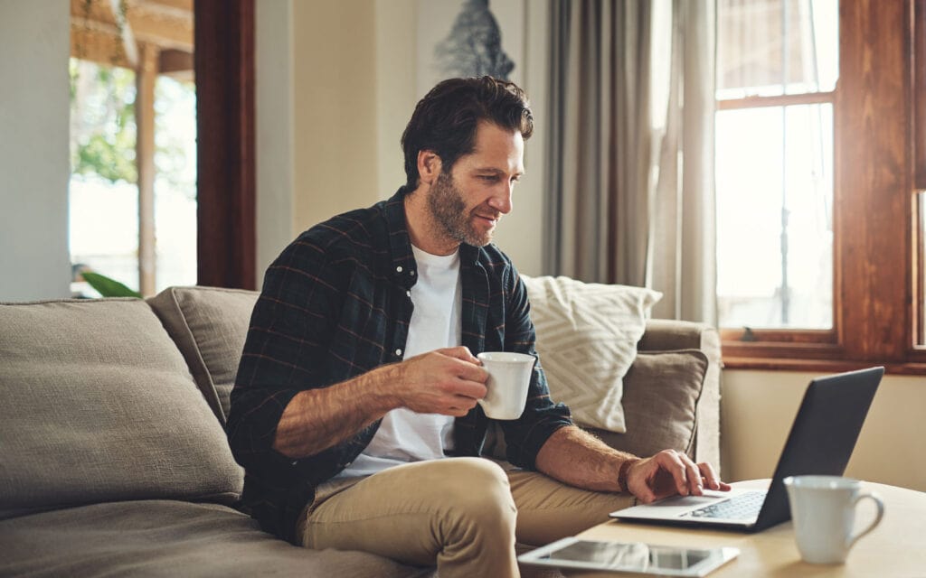 a man drinking coffee and applying for a loan